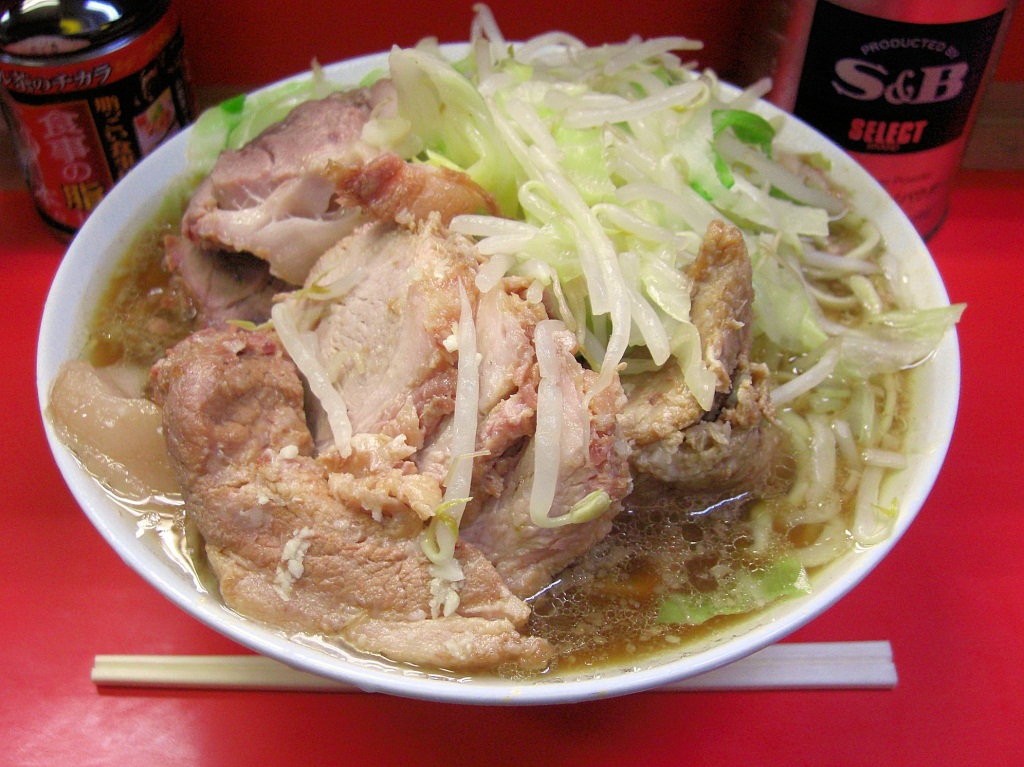 ラーメン二郎。写真は三田本店のもの。大量の厚切りチャーシュー、スープに厚く溜まる背脂、山盛りのモヤシキャベツが特徴。