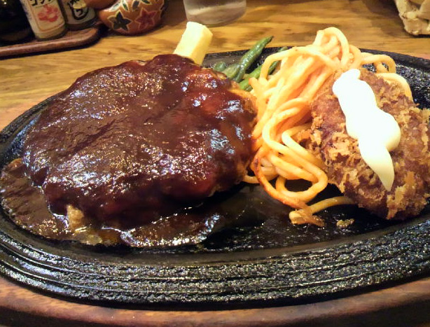 鉄板に乗せて出されるハンバーグ。ソースはデミグラソース。付け合せは、フレンチフライ、インゲン、スパゲティ。ここではヒレカツも付いている。